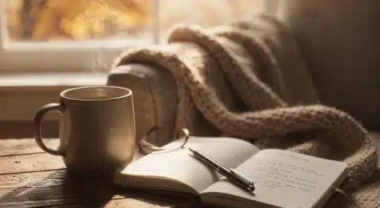 Cozy autumn setting with warm tea, journal, and fall leaves representing a fall self-care routine