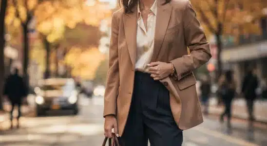 Professional woman wearing fall work wardrobe basics including a camel blazer and wide-leg trousers.